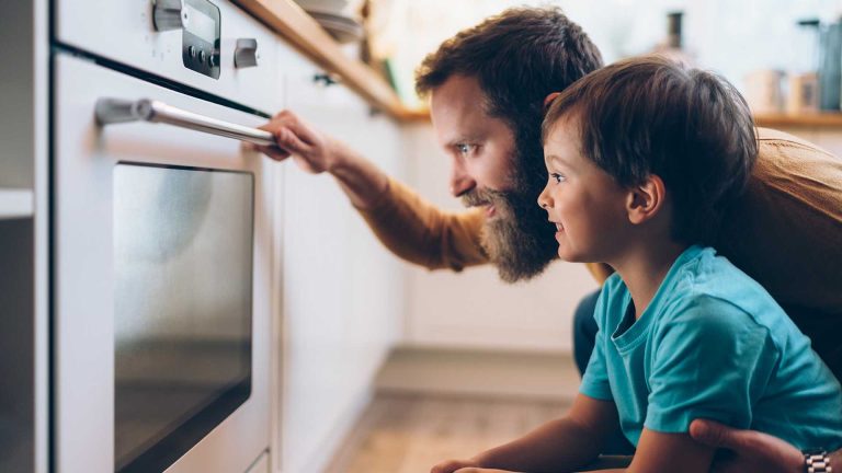 un uomo e un bambino che guardano un forno