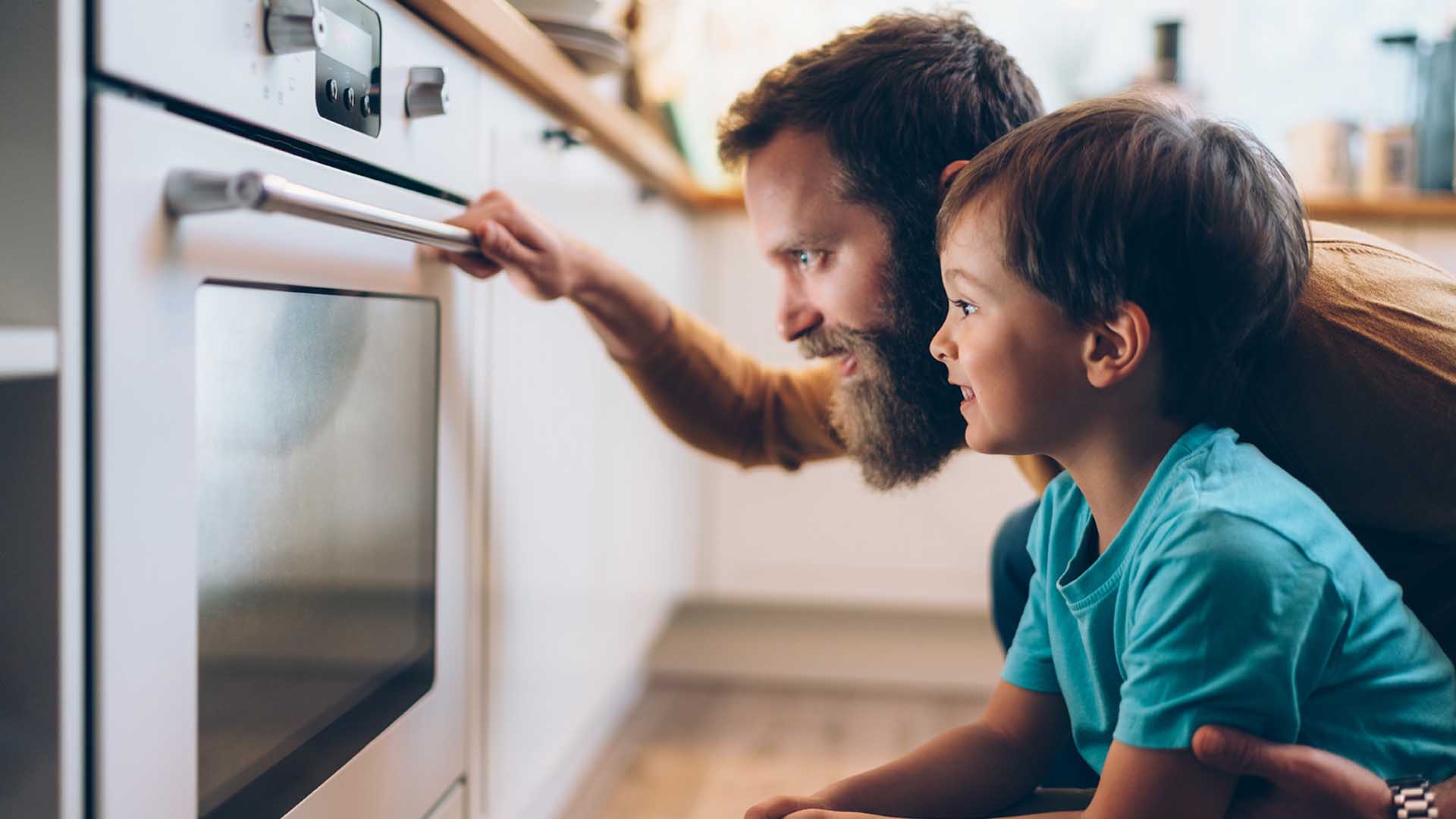 un uomo e un bambino che guardano un forno