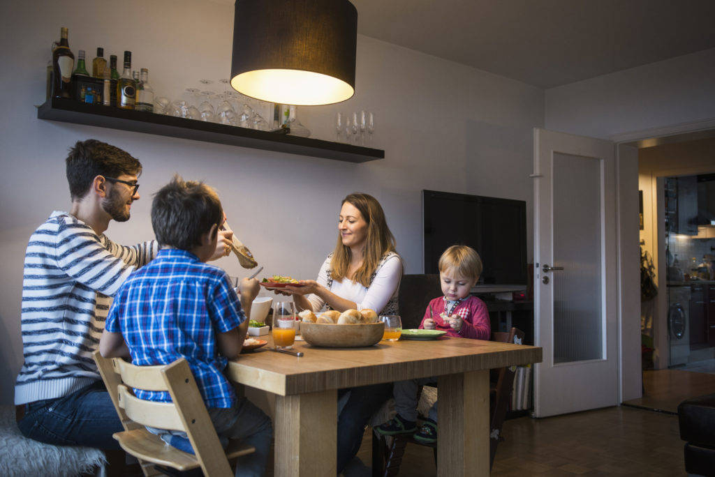 una famiglia seduta a un tavolo che mangia
