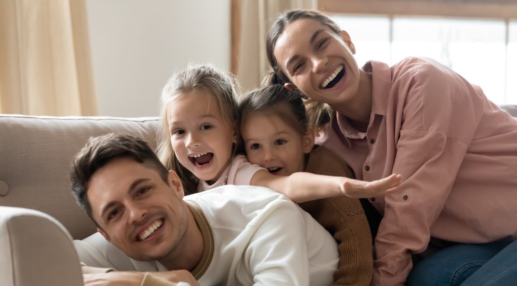 Famiglia felice sul divano insieme