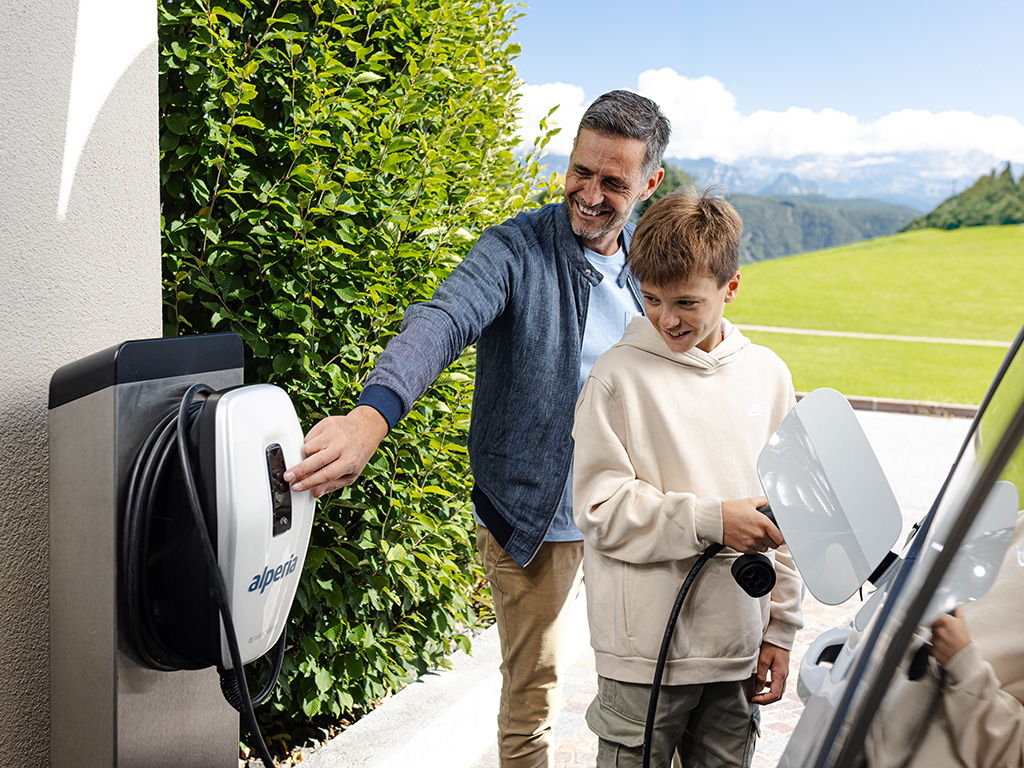 Padre e figlio ricaricano l'auto elettrica con la wallbox Alperia MyCharge